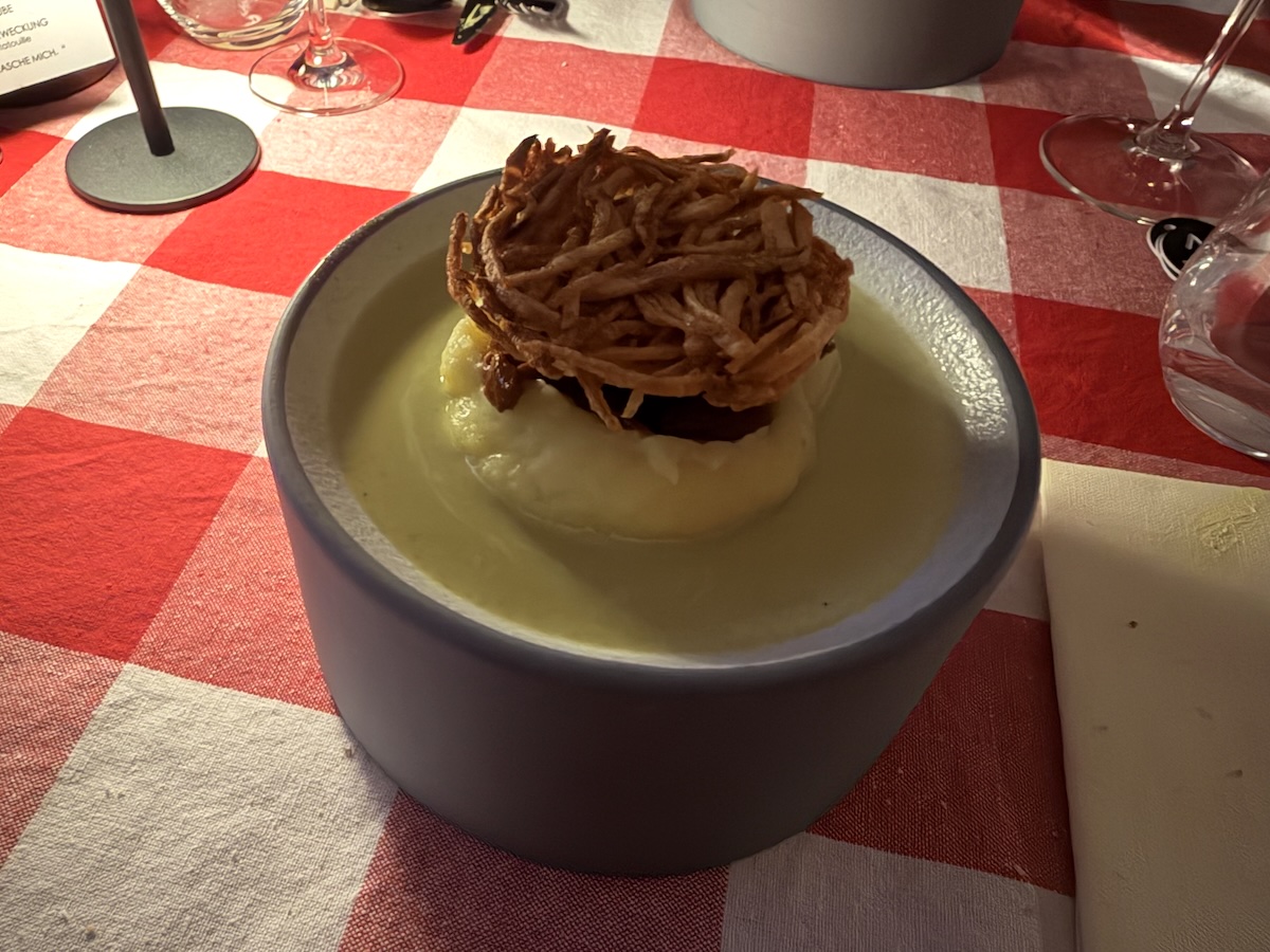 Cremiges Gericht mit knusprigem Topping auf rot-weiß karierter Tafel beim Ratatouille-Abend von Movie2Menu in Berlin