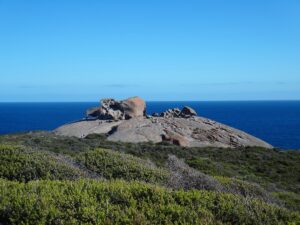 Graue Granitfelsen der Remarkable Rocks ragen vor tiefblauem Meer an der Küste von Kangaroo Island auf.