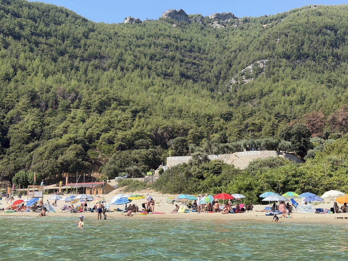 Paradise Beach auf Thassos mit Sandstrand, türkisfarbenem Meer und bewaldeten Bergen