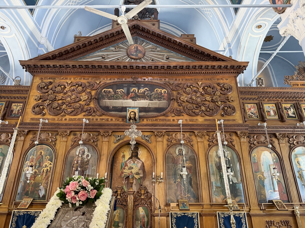 Eine reich geschnitzte Ikonostase mit Heiligenbildern und Blumen schmückt den Innenraum einer orthodoxen Kirche auf Thassos.