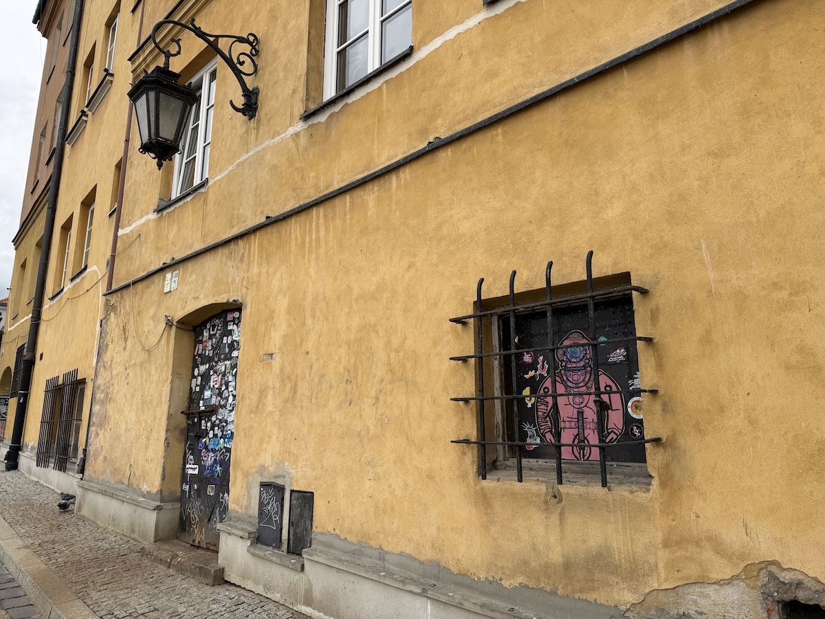 Historische gelbe Fassade mit Streetart in der Warschauer Altstadt