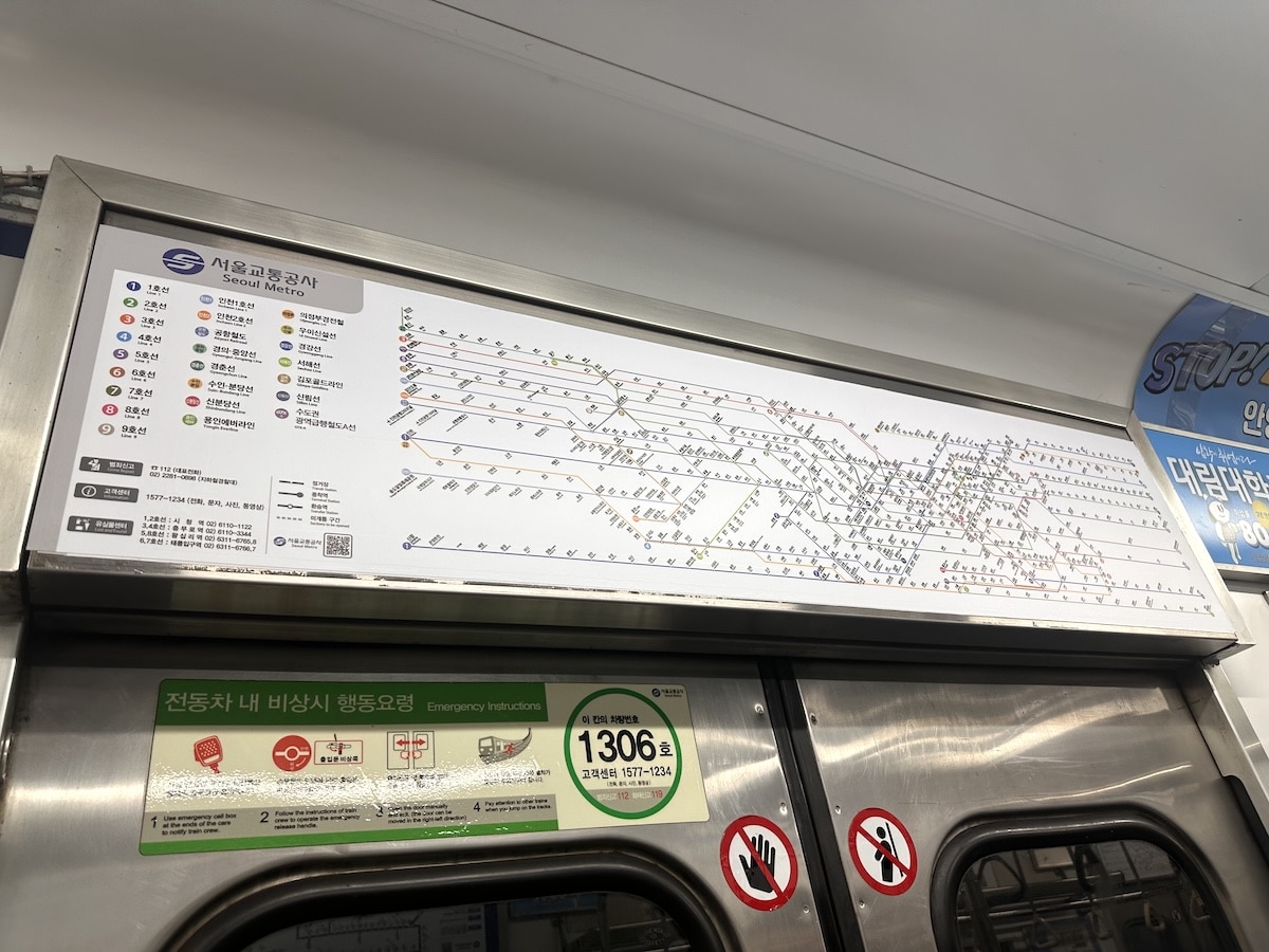 Ein detaillierter Streckenplan der Seoul Metro zeigt Linien, Stationen und Umstiege über den Türen eines U-Bahn-Wagens.