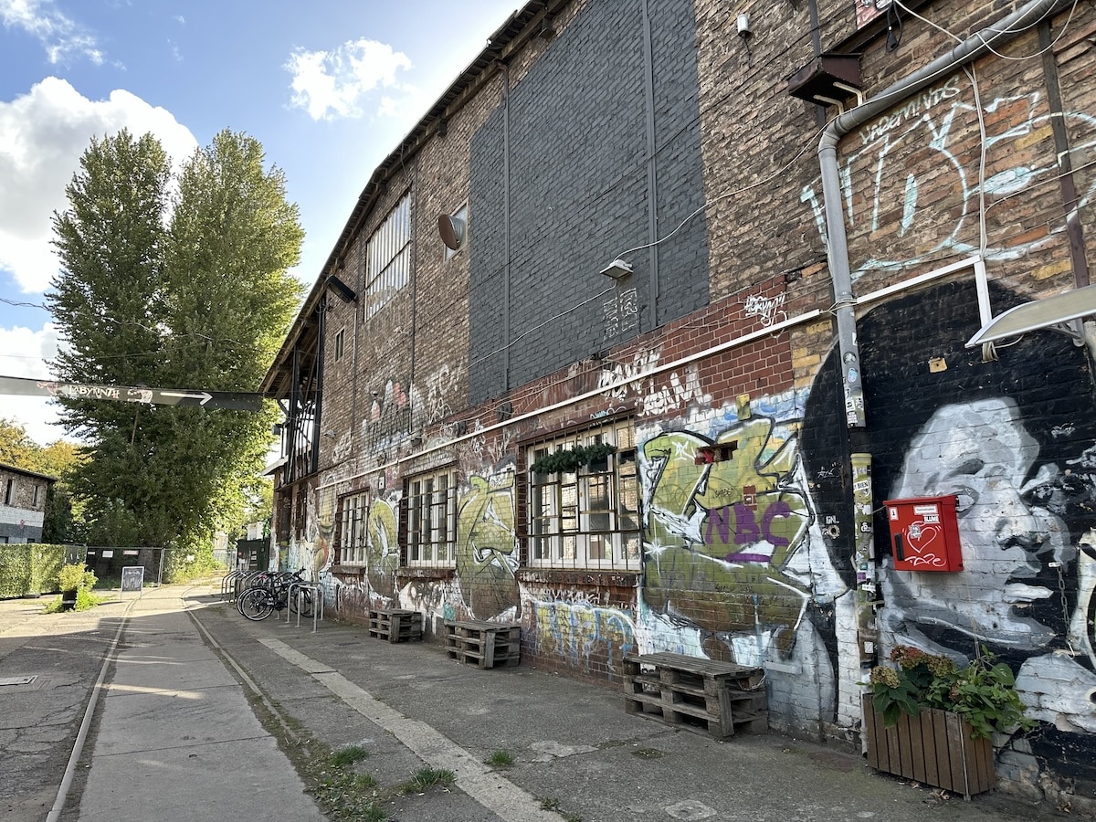 Bunte Graffiti schmücken eine alte Backsteinhalle am RAW-Gelände und zeigen die raue Vielfalt urbaner Kunst in Berlin.