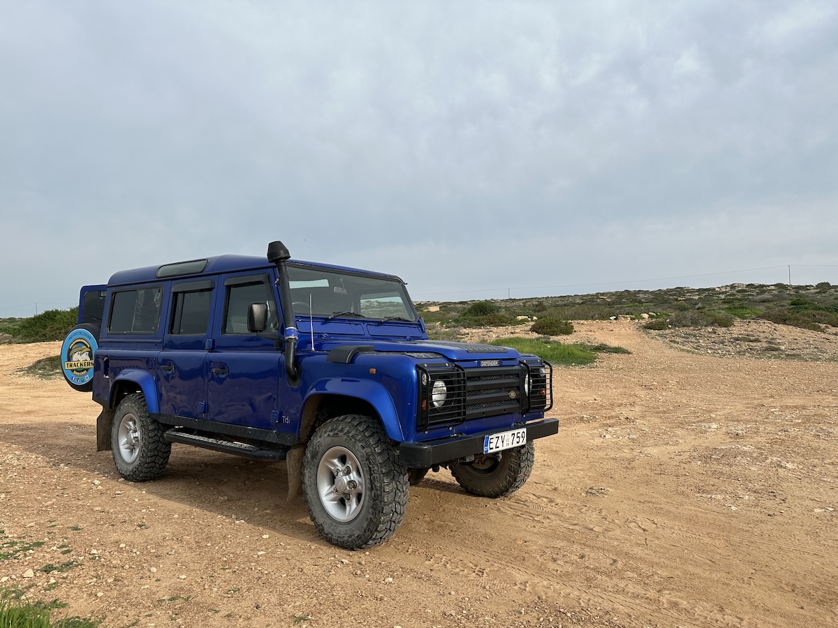 Ein blauer Geländewagen steht auf einer Schotterpiste bei Ayia Napa während einer Jeep Tour entlang der Ostküste.