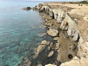 Geschichtete Felsküste mit Höhlen und türkisem Meer bei den Sea Caves am Cape Greco nahe Ayia Napa auf Zypern.