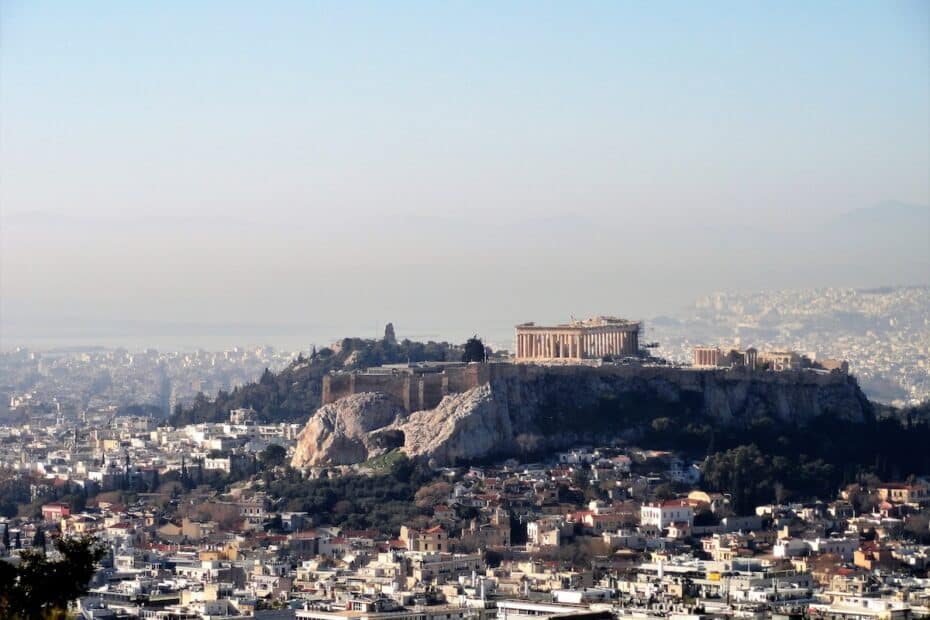 Über den Dächern von Athen erhebt sich die Akropolis mit dem Parthenon auf einem markanten Felsen im klaren Tageslicht.